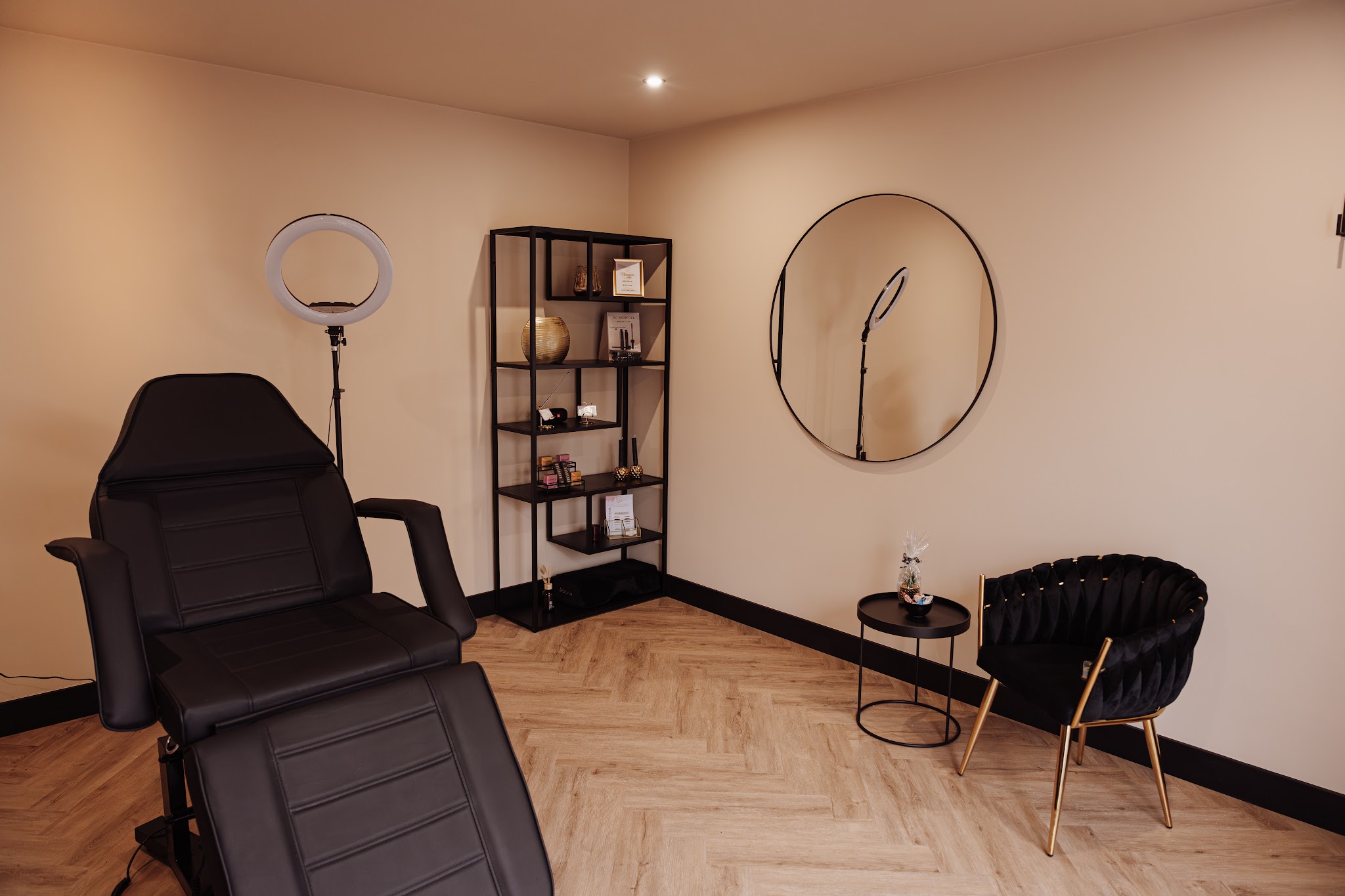 De behandelstoel, ronde spiegel en het warme interieur van Perfect Glance